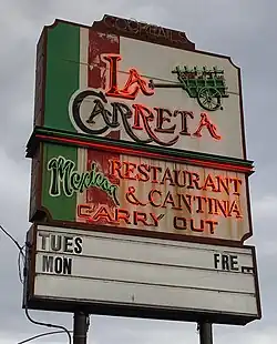 Photograph of a neon sign with the text "La Carreta Mexican Restaurant and Cantina" and "Carry Out"
