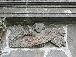 An angel holds a banner inscribed in Breton "AN:MARO:HAN:BARN:HAN:INFERN:IEN:PA:HO:SOING:DEN:E:TLE:CRENA FOL:EO NA:PREDER" which translates as "La Mort, le Jugement, l'Enfer glacé, quand l'homme y songe, il doit trembler" or "Death, judgment, freezing hell. Think on that and fear it".[4]
