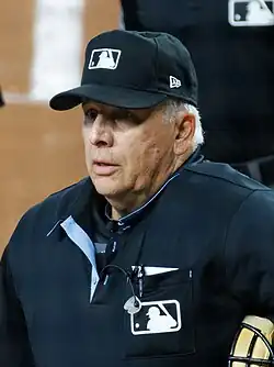 Photograph of Larry Vanover as home plate umpire holding his mask in his left arm