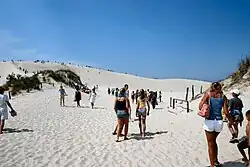 Beachgoers on the white sand dunes of Łeba