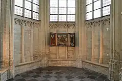 Triptych on the interior northwest stone wall of the apse chapel of Saint Peter's Church in Leuven, Belgium, from 2012.