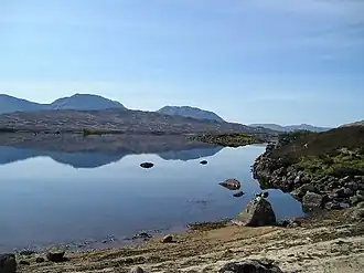 An upland lake with hills in the distance