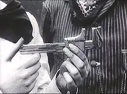 Close-up of a wrench held in a woman's hands, mistaken for a gun