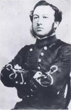 photograph of a man sitting upright, wearing a grey dress uniform