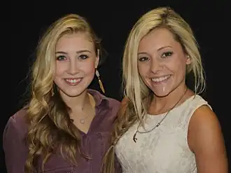 Two young blonde-haired women smiling broadly