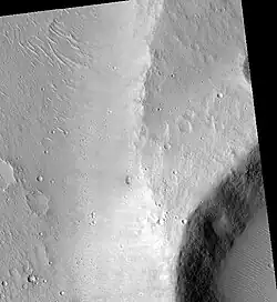 Maja Valles streamlined island in the Lunae Palus quadrangle of Mars, as seen by HiRISE. Island formed behind the impact crater at the lower right.