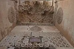 View from below of the stonework inlay, reliefs, and muqarnas vault in the portal