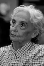 Headshot of a woman in slight profile, with white hair