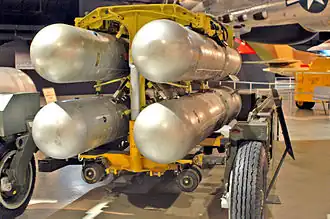 Four silver B28FI nuclear bombs in a rack ready for loading into an aircraft.