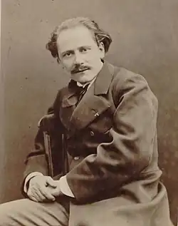 Middle-aged man, receding hair, moustached, looking at camera