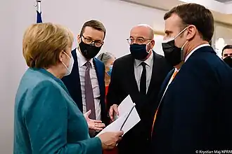 German chancellor Angela Merkel (left foreground), Polish prime minister Mateusz Morawiecki (center-left foreground), European Council president Charles Michel (center-right foreground), and French president Emmanuel Macron (right foreground), amidst a discussion in Brussels during a European Union summit, 10 December 2020