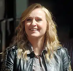 Melissa Etheridge, a White woman with long blonde hair, wearing a black, leather jacket