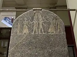 Merneptah stele showing a carving of merneptah being given a khopesh by Amun