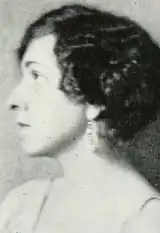White woman with short wavy hair, in profile.