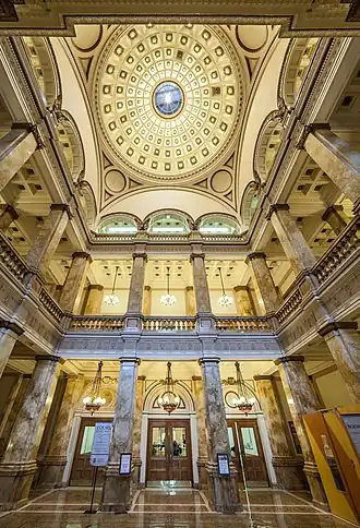The elegant interior of the dome and rotunda, including marble pillars, arches, ornate fixtures, and a mosaic floor.