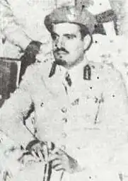 Photo of three men seated, on the right is Mishaal