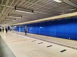 A blue wall with the artwork figures