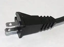 One blade is wider on a polarized 1-15P plug.