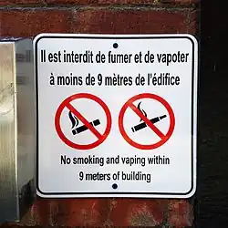 The sign states: No smoking and vaping within 9 meters of building.