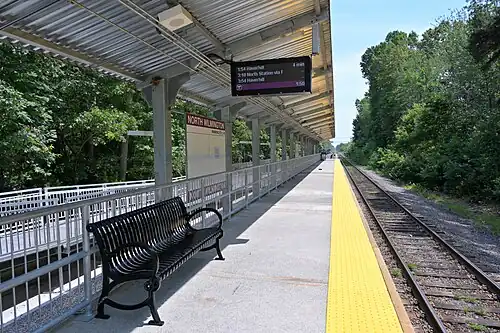 A high-level railway platform next to a single track