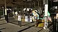 A historic carousel with a bi-level platform wit ha metal fence in the foreground