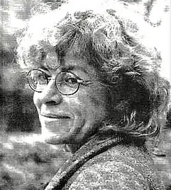 Black-and-white portrait of Odile Bailleux, a white, elderly woman with wavy hair, wearing glasses and a formal suit.