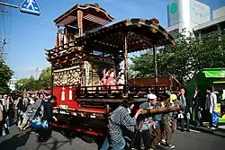 Festival float with attached small roofed stage and dolls
