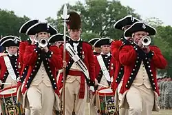 The United States Army Old Guard Fife and Drum Corps thrill an audience with their musical skills while on parade in 2008. The unit recalls the American Revolutionary era by dressing in colonial uniform and tricorn hats.
