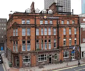 Former Market Hotel (to the left of the Old Rep). Built in sandstone in 1883 by Thomson Plevins. At the back of the hotel the original workshop of the Old Rep can just be seen. The building became Grade II Listed in November 2024.
