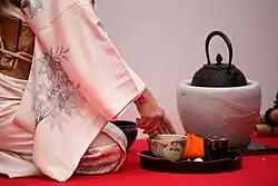 A hostess prepares matcha during a Japanese outdoor tea ceremony