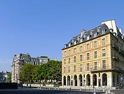 Rue de Harlay seen from the Quai de l'Horloge [fr]. In the foreground: Hôtel de Barlay (Maison du Barreau), the building at no. 2. Place Dauphine is behind the trees.