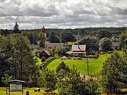 A view of the village from the hill. The graffiti on the information board in the foreground signifies local allegiance to Lechia Gdańsk