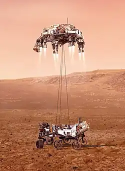 An illustration of Perseverance tethered to the sky crane.