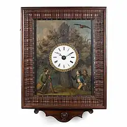 Picture frame timepiece, c. 1870. Enamel dial in a rectangular painting on a sheet metal: a hunter lies in wait for a hovering bird of prey, while two boys look at the tree stump in which the camouflage cuckoo's door is located (Deutsches Uhrenmuseum, Inv. 05–0962)