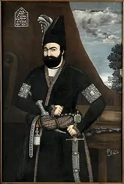 Illustration of a bearded monarch wearing black robes and a cummerbund, Persian text can be seen on the top left