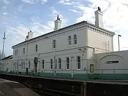 Platform-side view of the main building from rail height, standing on the adjacent level crossing