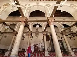 The prayer hall, with calligraphic stucco outlines around the arches and carved wooden tie-beams from the Fatimid era