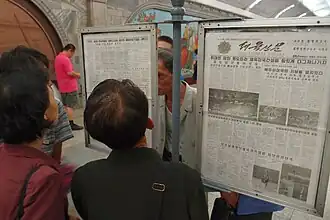 A public newspaper display on a platform