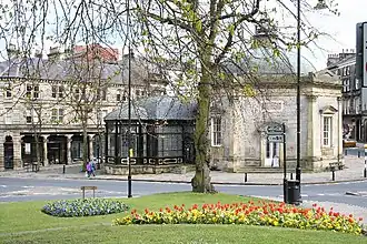 The stone, octagonal building of the Royal Pump Room with a glass dome and glass extension to the left side.