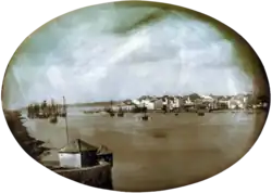 An elevated view across the Capibaribe River to Recife's harbor with the city in the background