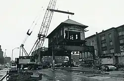 A elevated rapid transit station being disassembled with a cran