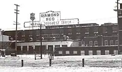 A large building with a sign reading "Diamond Reo – World's Toughest Truck" sign on the roof and industrial surroundings.