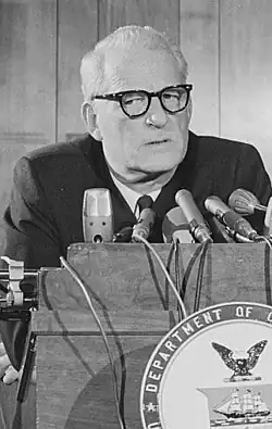 photo of Richard Morse wearing eyeglasses, standing at a lecturn