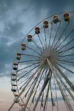 View of a Ferris wheel with white structure during twilight.