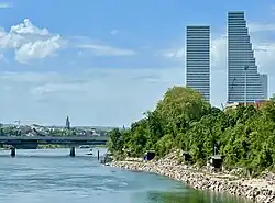 Roche Towers (Building 1 and 2) in Basel, Switzerland, with traditional fishing cranes in the foreground