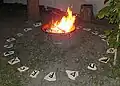 Brazier with burning fire in a rune stone circle at a summer solstice