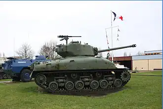 A M4 Sherman tank profile view and a VXB-170 Berliet partially hidden by the tank.