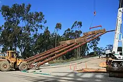 Falsework erection: A section is lifted to a vertical position with the assistance of two forklift operators.