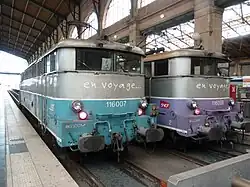 Two “en voyage” liveries, one blue, the other purple.