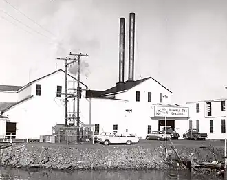 Photograph of the Samuel Elmore Cannery while it was in operation, with a "Bumble Bee" sign hanging above the door.